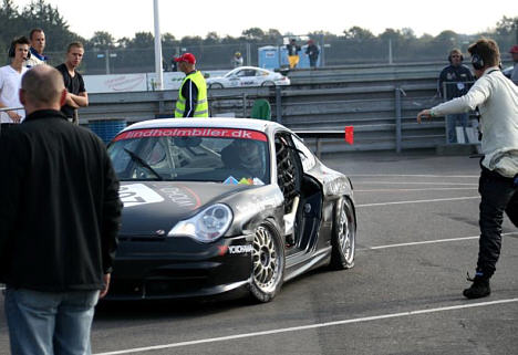 Jan Kalmar (T.h.) dirigerer Martin Kristensen og den skadede Porsche over til mekanikerne.